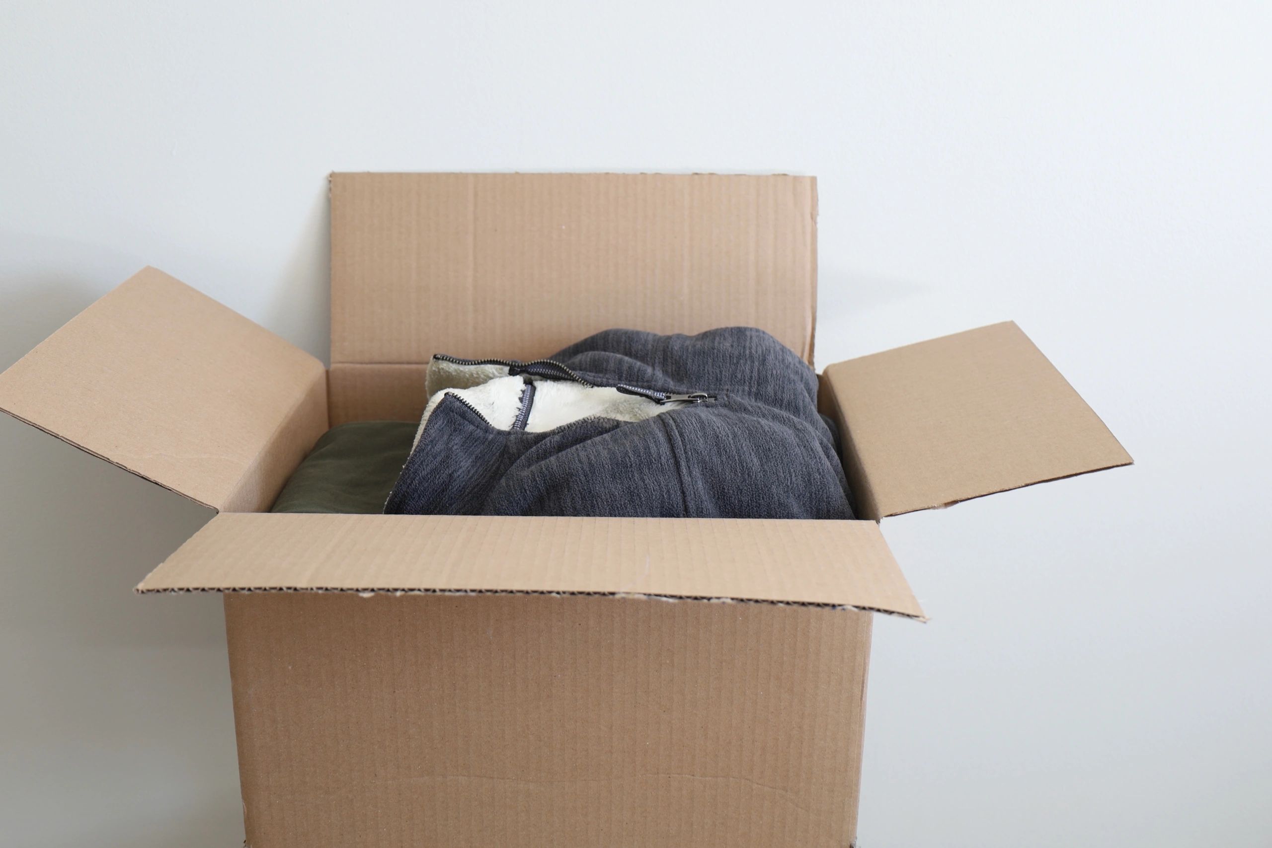 Open shipping box with folded clothing inside